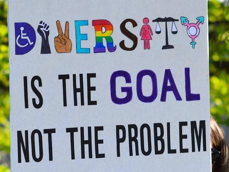 Colorful diversity sign promoting equality and inclusion, featuring hands and equality symbols.
